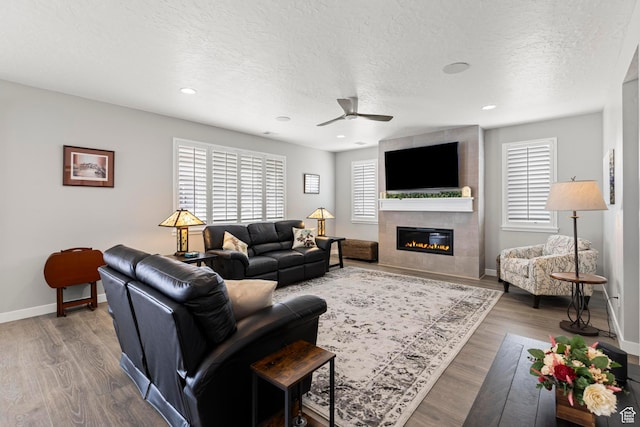 415 W 1410 N Unit 81, Tooele, UT 84074 - living area with baseboards, a tile fireplace, wood finished floors, a textured ceiling, and a ceiling fan