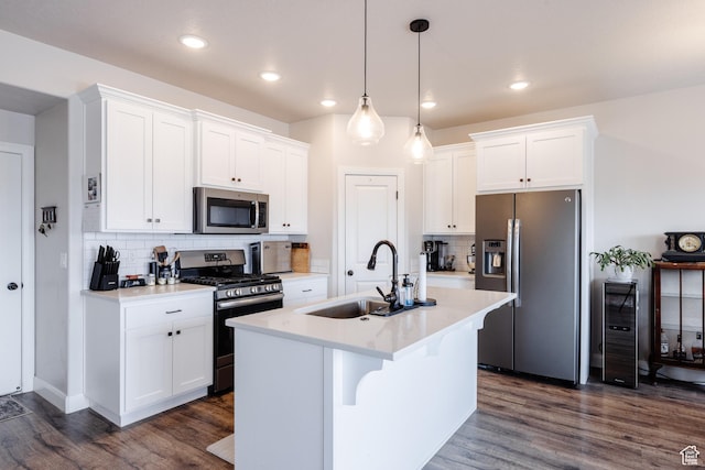 kitchen with dark wood-style floors, stainless steel appliances, light countertops, and a sink
