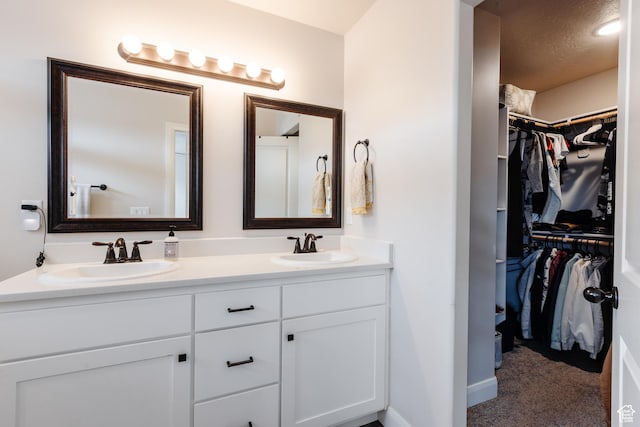 3084 W 1750 N Unit 1, Cedar City, UT 84721 - bathroom with a sink, a textured ceiling, a spacious closet, and double vanity