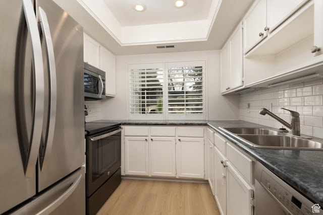 1525 E Waterbury Dr Unit D, Salt Lake City, UT 84121 - kitchen featuring stainless steel appliances, a sink, light wood-style floors, white cabinetry, and dark countertops