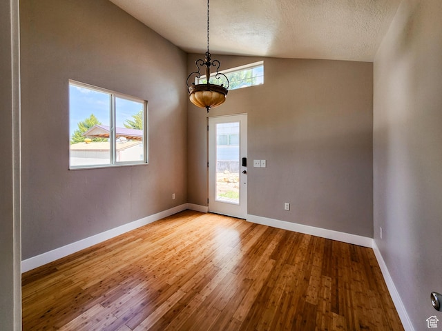 3030 S Edgemont Dr Unit 159, Garden City, UT 84028 - interior space with baseboards, an inviting chandelier, lofted ceiling, hardwood / wood-style flooring, and a textured ceiling