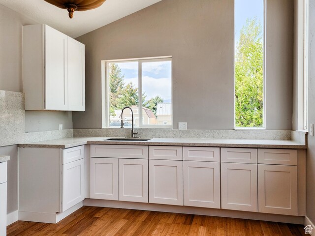 3030 S Edgemont Dr Unit 159, Garden City, UT 84028 - kitchen featuring light wood-type flooring, light countertops, lofted ceiling, white cabinets, and a sink