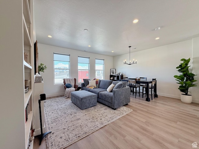 living room featuring a notable chandelier, recessed lighting, light wood-type flooring, and baseboards
