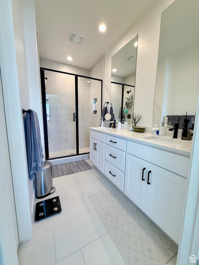 full bathroom featuring visible vents, a shower stall, double vanity, recessed lighting, and a sink
