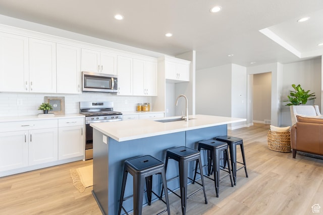3077 N 2875 W Unit 5, Plain City, UT 84404 - kitchen with light wood-style flooring, a sink, stainless steel appliances, white cabinets, and recessed lighting