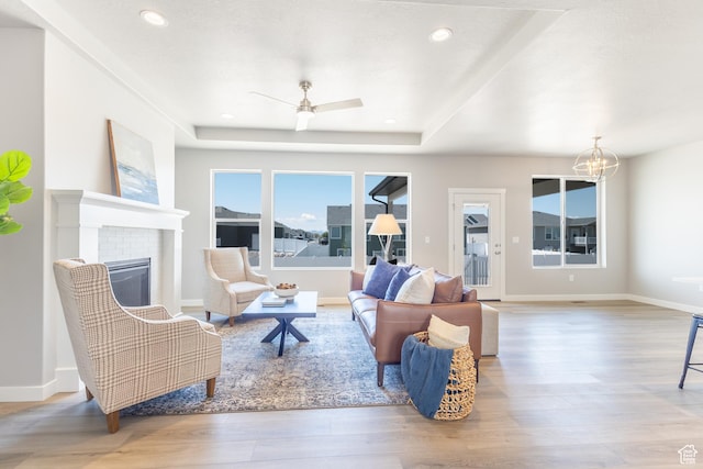3077 N 2875 W Unit 5, Plain City, UT 84404 - living area with wood finished floors, ceiling fan with notable chandelier, a tray ceiling, a brick fireplace, and recessed lighting