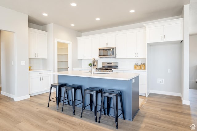 3077 N 2875 W Unit 5, Plain City, UT 84404 - kitchen with backsplash, stainless steel appliances, a kitchen island with sink, and a sink