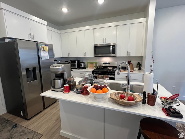 933 N 960 W Street W W 4, Tremonton, UT 84337 - kitchen with a kitchen breakfast bar, light wood-style flooring, recessed lighting, stainless steel appliances, and white cabinets
