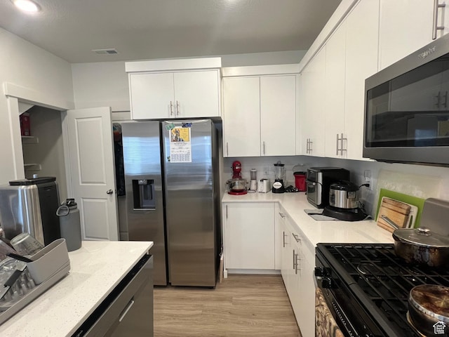 933 N 960 W Street W W 4, Tremonton, UT 84337 - kitchen featuring white cabinetry, light stone countertops, appliances with stainless steel finishes, light wood-style flooring, and visible vents