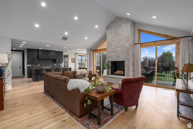 915 Farrell Farm Cir, Midway, UT 84049 - living area featuring visible vents, high vaulted ceiling, a fireplace, and light wood finished floors