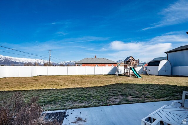 1490 N 4925 W, Plain City, UT 84404 - view of yard featuring an outdoor structure, a playground, a fenced backyard, and a shed