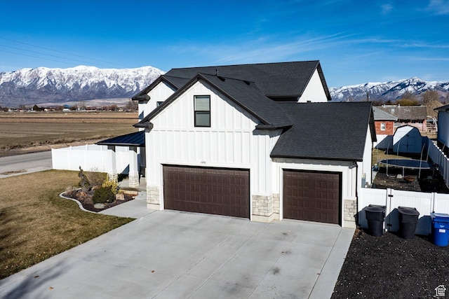 1490 N 4925 W, Plain City, UT 84404 - view of front of property featuring a mountain view, driveway, board and batten siding, and fence