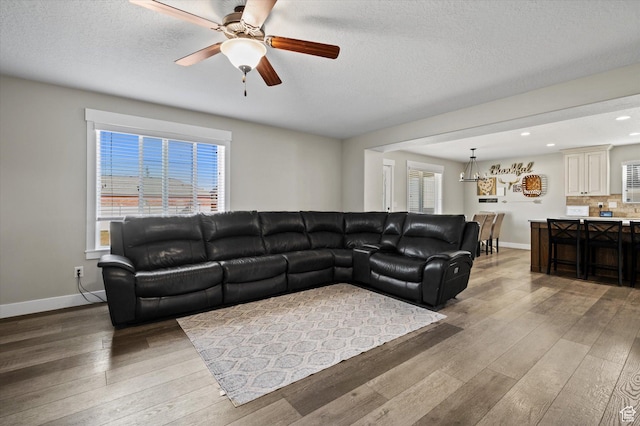 1490 N 4925 W, Plain City, UT 84404 - living area featuring light wood-style flooring, ceiling fan with notable chandelier, and baseboards