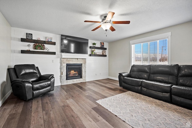 1490 N 4925 W, Plain City, UT 84404 - living area with wood-type flooring, a textured ceiling, a stone fireplace, and a ceiling fan