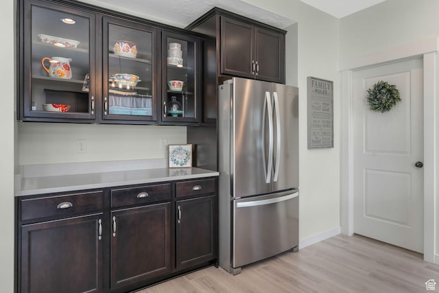 1843 E 970 N, Spanish Fork, UT 84660 - kitchen featuring glass insert cabinets, light countertops, freestanding refrigerator, dark brown cabinets, and light wood finished floors