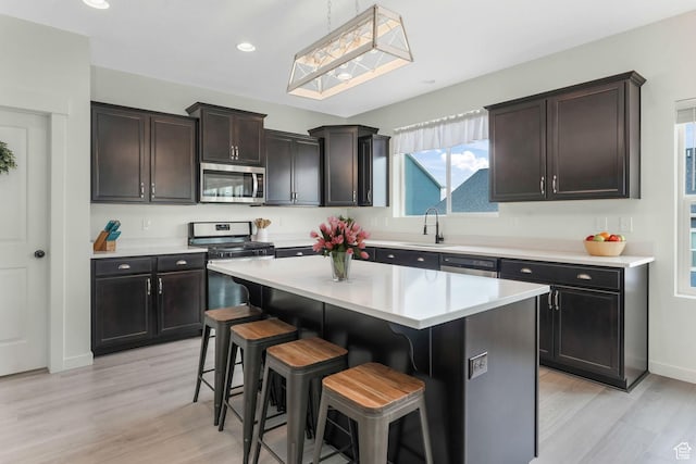 1843 E 970 N, Spanish Fork, UT 84660 - kitchen with a breakfast bar, light countertops, appliances with stainless steel finishes, light wood finished floors, and a sink