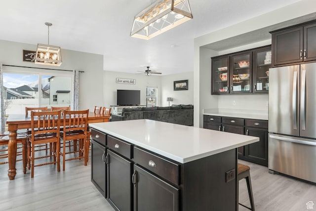 1843 E 970 N, Spanish Fork, UT 84660 - kitchen with glass insert cabinets, a center island, light countertops, light wood-type flooring, and freestanding refrigerator