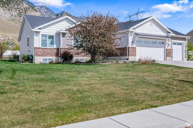 7114 N 2275 W, Honeyville, UT 84314 - view of front of house with a front lawn, an attached garage, driveway, brick siding, and a mountain view