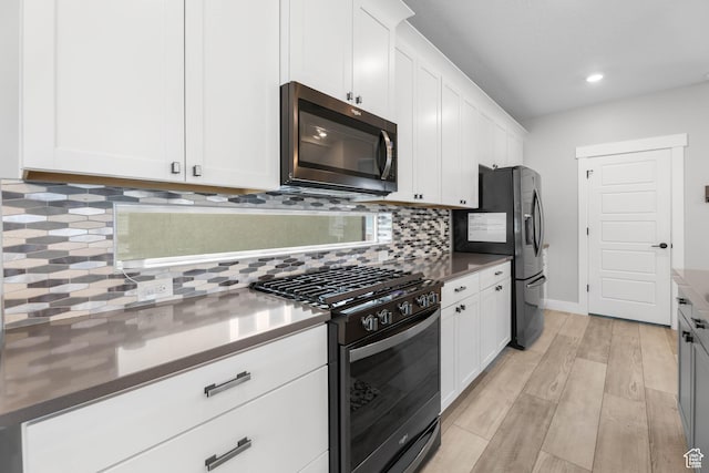 53 E Polaris Dr, Saratoga Springs, UT 84045 - kitchen featuring black appliances, white cabinets, light wood-style flooring, and tasteful backsplash