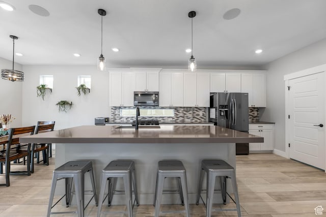 53 E Polaris Dr, Saratoga Springs, UT 84045 - kitchen with dark countertops, refrigerator with ice dispenser, a breakfast bar area, and tasteful backsplash