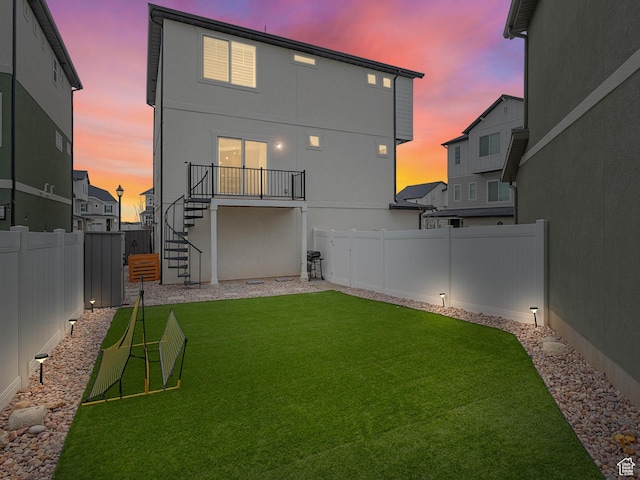 53 E Polaris Dr, Saratoga Springs, UT 84045 - back of house featuring stairs, a fenced backyard, a lawn, and stucco siding