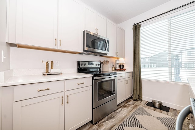 198 W Box Creek Dr, Stansbury Park, UT 84074 - kitchen with white cabinets, stainless steel appliances, light wood-style flooring, baseboards, and light countertops