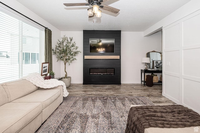 198 W Box Creek Dr, Stansbury Park, UT 84074 - living area featuring baseboards, wood finished floors, a large fireplace, and ceiling fan