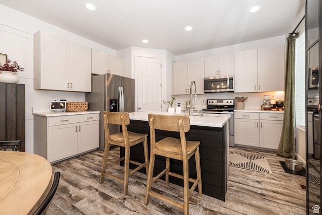198 W Box Creek Dr, Stansbury Park, UT 84074 - kitchen with wood finished floors, a sink, stainless steel appliances, light countertops, and recessed lighting
