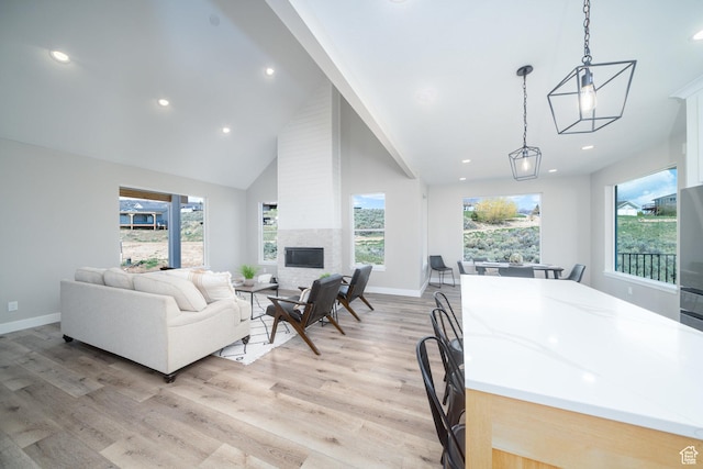 2678 S Eagle Dr Unit 12, Garden City, UT 84028 - living room featuring baseboards, light wood-style flooring, a fireplace, and high vaulted ceiling