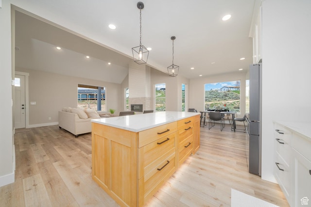 2678 S Eagle Dr Unit 12, Garden City, UT 84028 - kitchen featuring light wood-type flooring, light brown cabinets, open floor plan, and a multi sided fireplace