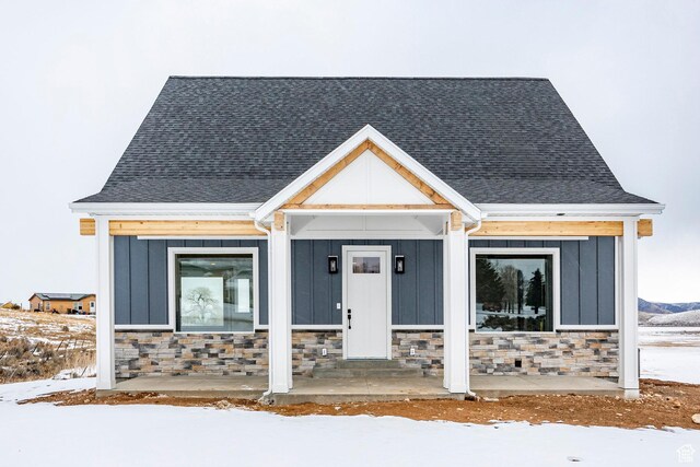 2678 S Eagle Dr Unit 12, Garden City, UT 84028 - view of front of home with covered porch, a shingled roof, stone siding, and board and batten siding