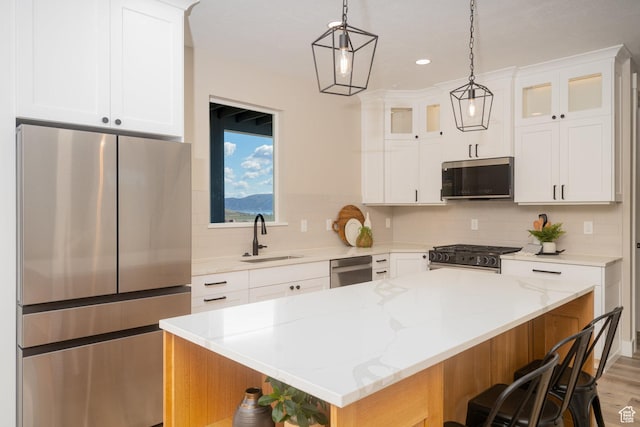 2678 S Eagle Dr Unit 12, Garden City, UT 84028 - kitchen featuring a breakfast bar area, glass insert cabinets, a sink, appliances with stainless steel finishes, and decorative backsplash