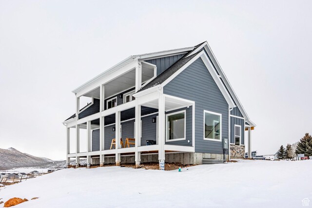 2678 S Eagle Dr Unit 12, Garden City, UT 84028 - snow covered back of property featuring a mountain view and board and batten siding