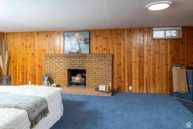 bedroom with carpet flooring, a brick fireplace, and wooden walls
