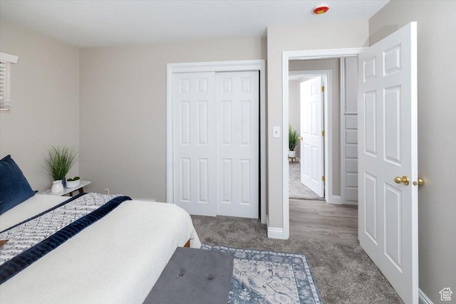 carpeted bedroom featuring baseboards and a closet