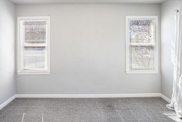 carpeted spare room with a healthy amount of sunlight and baseboards