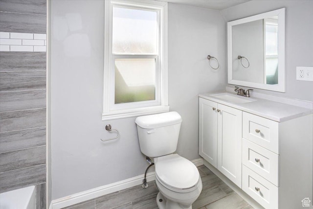 full bathroom with toilet, vanity, baseboards, and wood finished floors