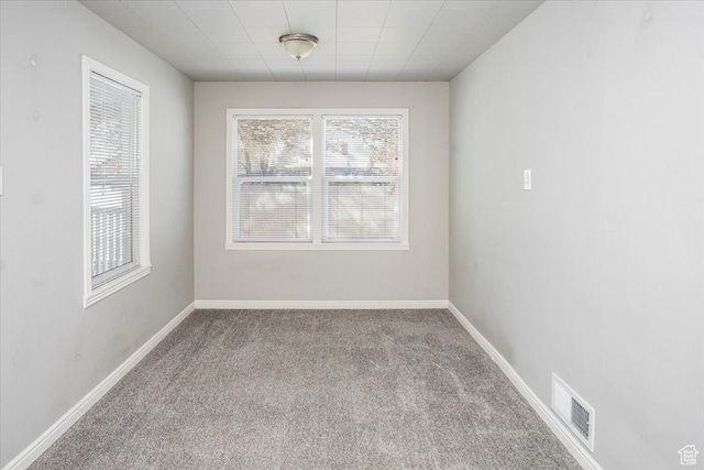 empty room with visible vents, baseboards, and carpet floors