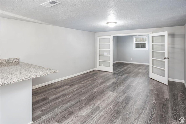 spare room featuring dark wood-style floors, french doors, visible vents, and baseboards