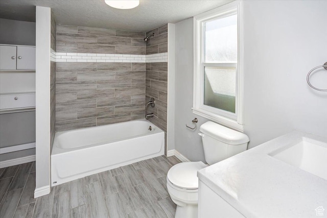 full bathroom featuring wood tiled floor, toilet, shower / bathtub combination, a textured ceiling, and vanity