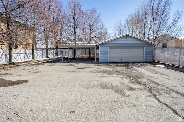 garage featuring a detached garage and fence