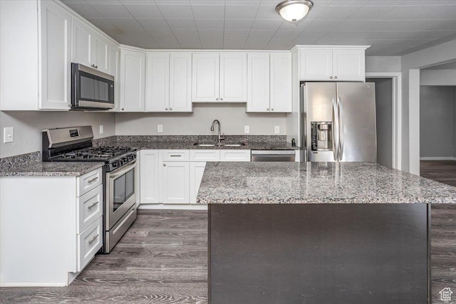 kitchen with dark wood-style floors, white cabinets, stainless steel appliances, and a sink