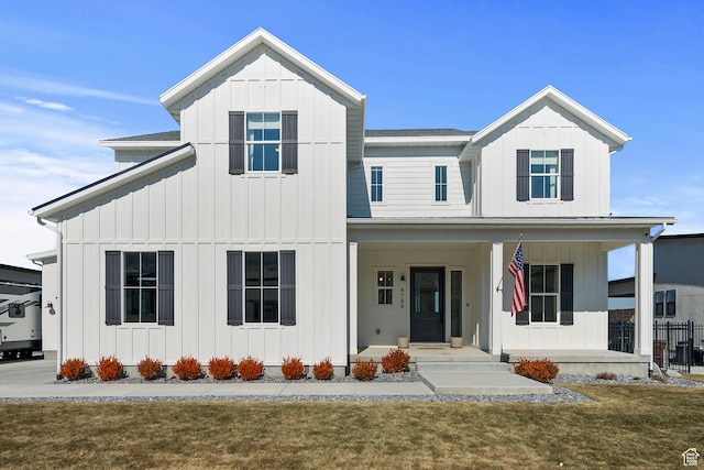modern inspired farmhouse with a porch, board and batten siding, and a front lawn