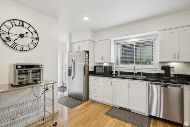 71 W Apricot Ave, Salt Lake City, UT 84103 - kitchen featuring light wood finished floors, white cabinets, stainless steel appliances, and a sink