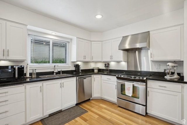 71 W Apricot Ave, Salt Lake City, UT 84103 - kitchen with light wood-style flooring, a sink, appliances with stainless steel finishes, white cabinetry, and wall chimney range hood
