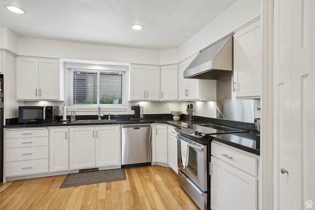 71 W Apricot Ave, Salt Lake City, UT 84103 - kitchen with wall chimney range hood, white cabinets, appliances with stainless steel finishes, and a sink