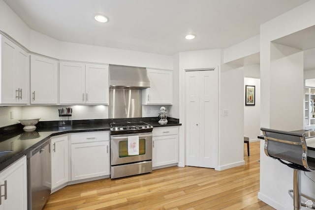 71 W Apricot Ave, Salt Lake City, UT 84103 - kitchen featuring stainless steel appliances, white cabinetry, dark countertops, exhaust hood, and light wood-type flooring