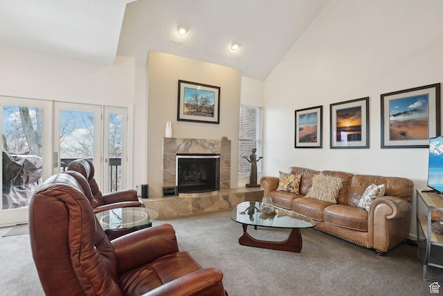 carpeted living room with high vaulted ceiling and a high end fireplace