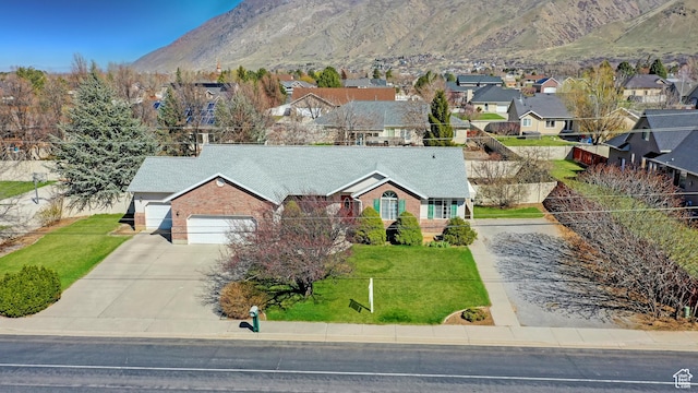 view of front of house featuring fence, an attached garage, a front yard, brick siding, and driveway