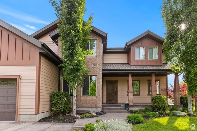 5927 Dartmouth Dr, Mountain Green, UT 84050 - view of front of home with board and batten siding, a porch, and brick siding